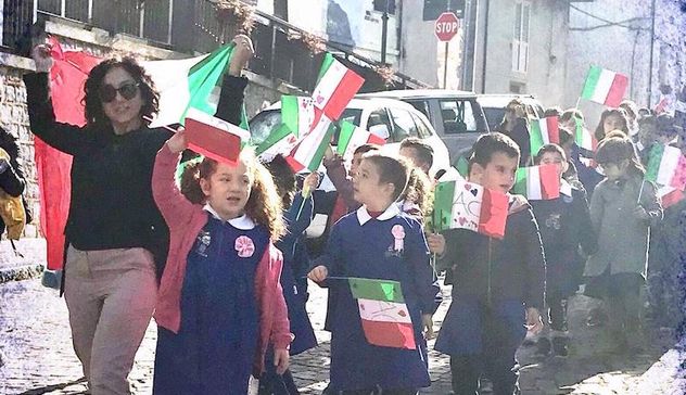 Cerimonia del quattro novembre: i bambini depongono le bandierine tricolori accanto al monumento ai caduti e cantano l’Inno nazionale