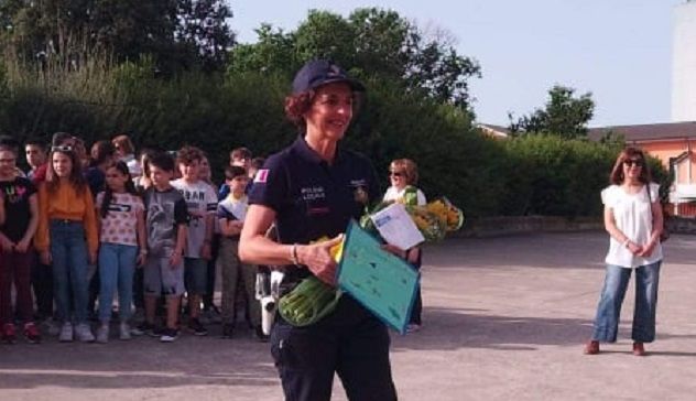 E' ora di vacanze: gli studenti regalano fiori al vigile che regola il traffico all'ingresso della scuola