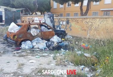 ‘Scheletri’ d’auto e bustoni colmi di rifiuti, benvenuti a Is Mirrionis. Le foto