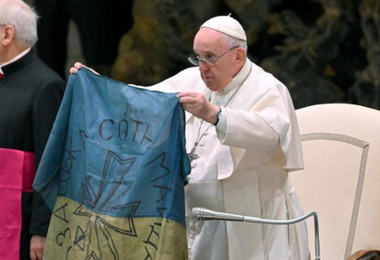 Il Papa mostra una bandiera proveniente da Bucha insieme ai bambini ucraini 